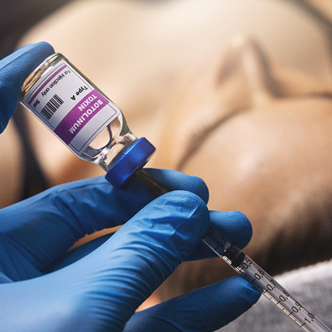 a dentist holding a BOTOX vial and syringe