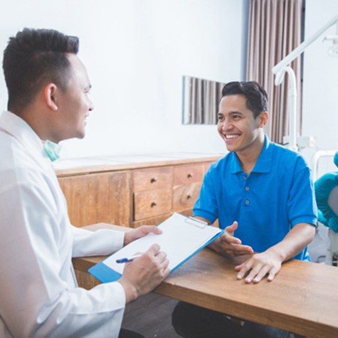 man smiling while talking to dentist