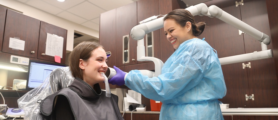 Dentist performing dental exam in Houston