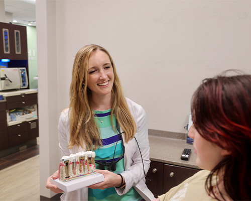 Dental team member talking to dental patient